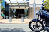 A motorbike outside a courthouse.