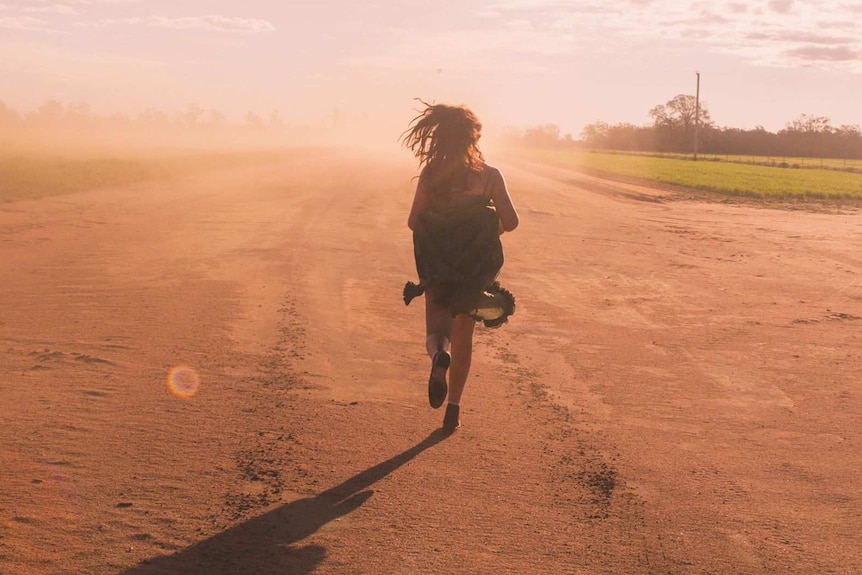 Woman running on a dusty runway.