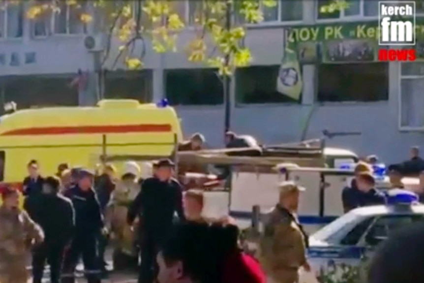 Emergency services load an injured person onto a yellow truck in Kerch, Crimea.