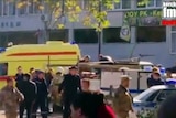 Emergency services load an injured person onto a yellow truck in Kerch, Crimea.