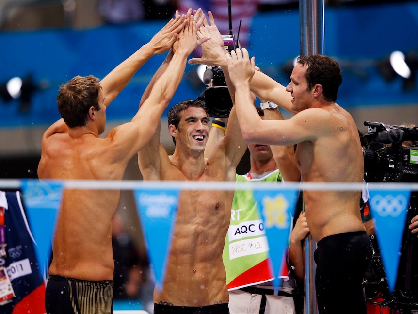 Michael Phelps, Matthew Grevers (L) and Brendan Hansen (R) celebrate the 4x...