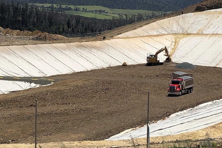 Trucks work on a large whole in the ground for a waste water project.