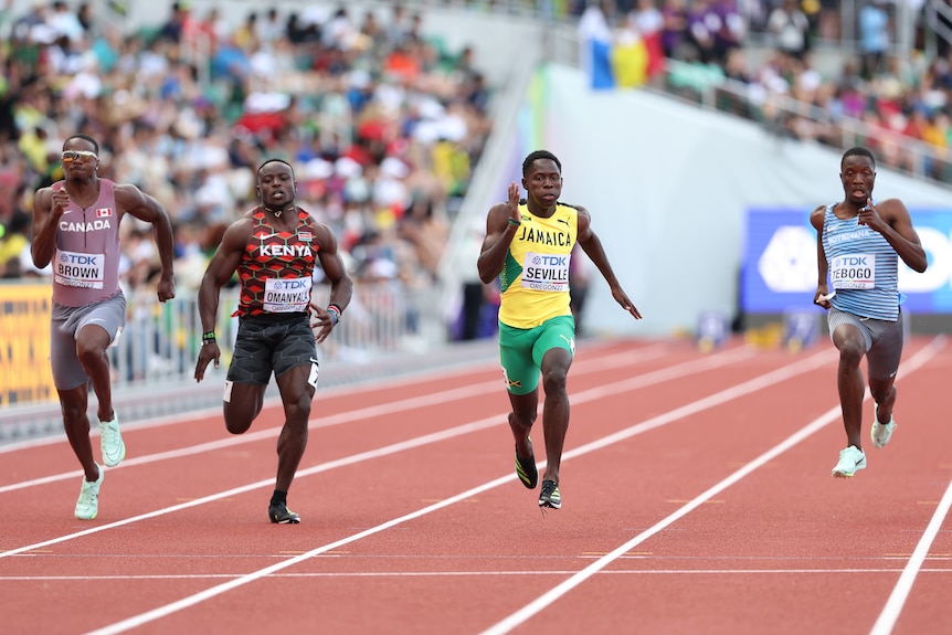 A head on shot of four men's 100m sprinters in full flight during a race