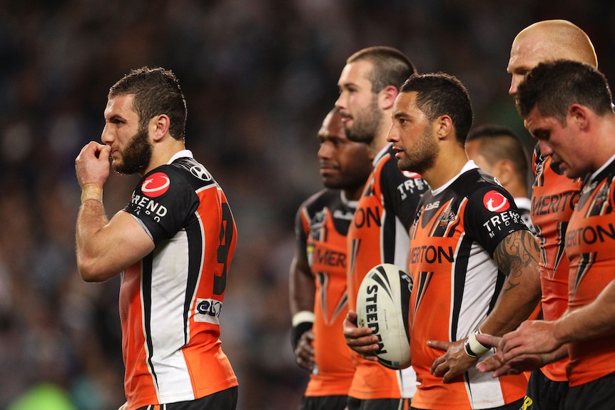 A group of men look forlorn after losing a rugby league match