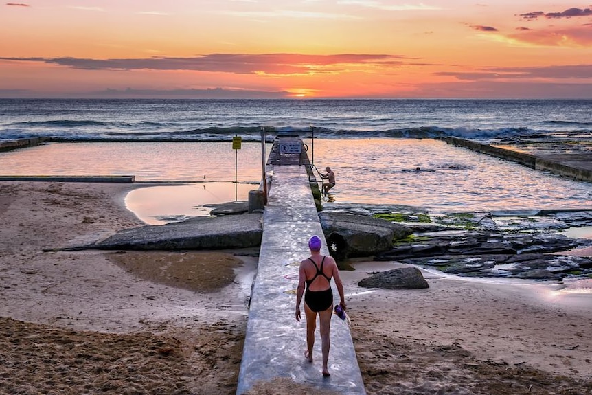 The sun rising over the ocean and sea baths at Austinmer, NSW