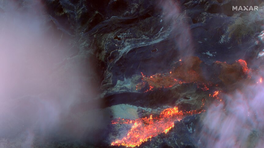 The same blaze is seen in infrared, with bright orange showing the actively burning fire.
