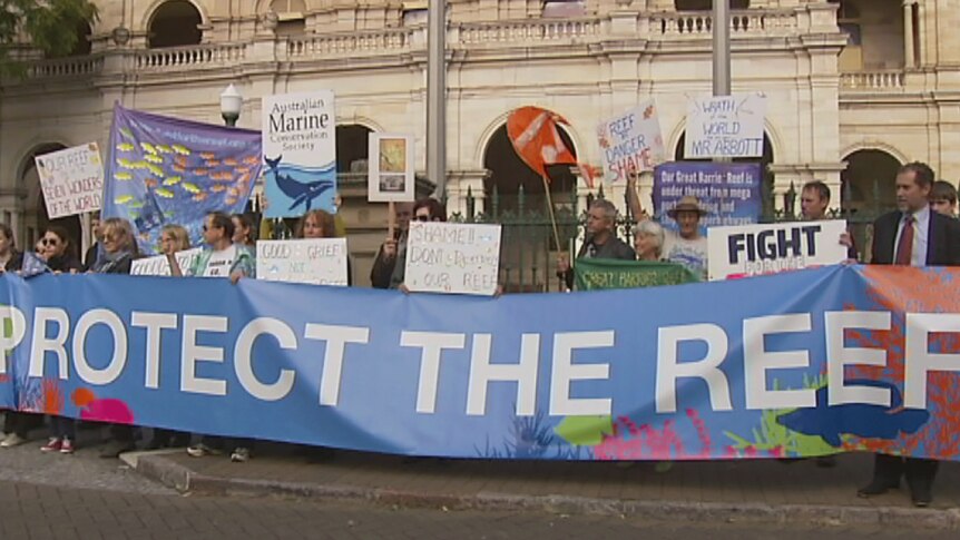 Marine Conservation Society supporters hold banners up urging a Senate inquiry to save the Great Barrier Reef from dredging