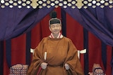 Emperor Naruhito in an orange robe.