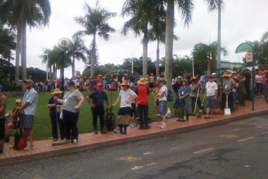 People line up in the street outside the Planetarium in Brisbane waiting to register as volunteers for the flood clean-up effort