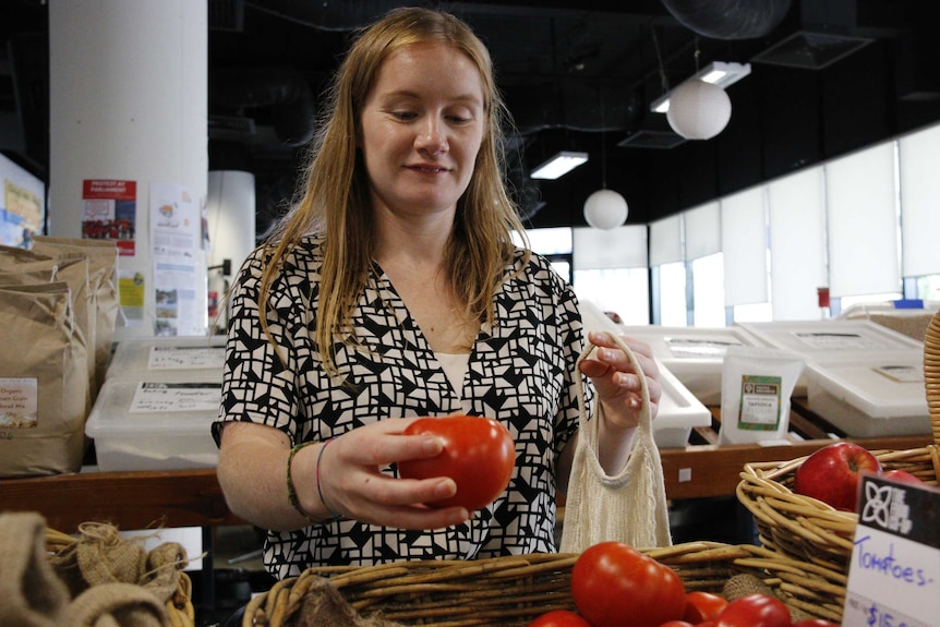 Sarah Power picks up a tomato.