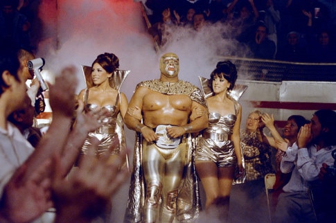 A still from Nacho Libre shows wrestler Cesar Cuauhtemoc Gonzalez Barron walking with two women.