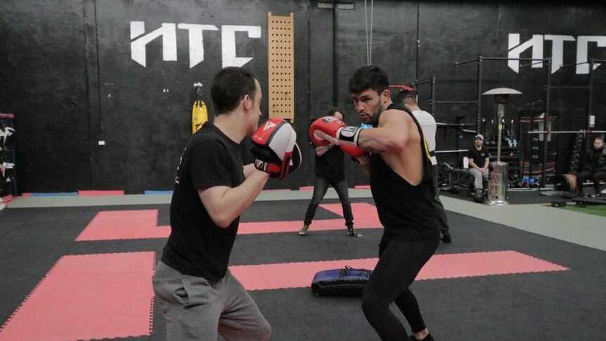 Two mixed martial arts fighters sparring in the gymnasium