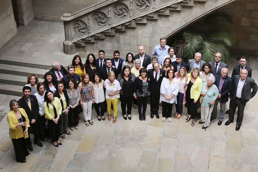 Members of the new Catalan Government are seen posing for a photo with relatives of the politicians jailed.