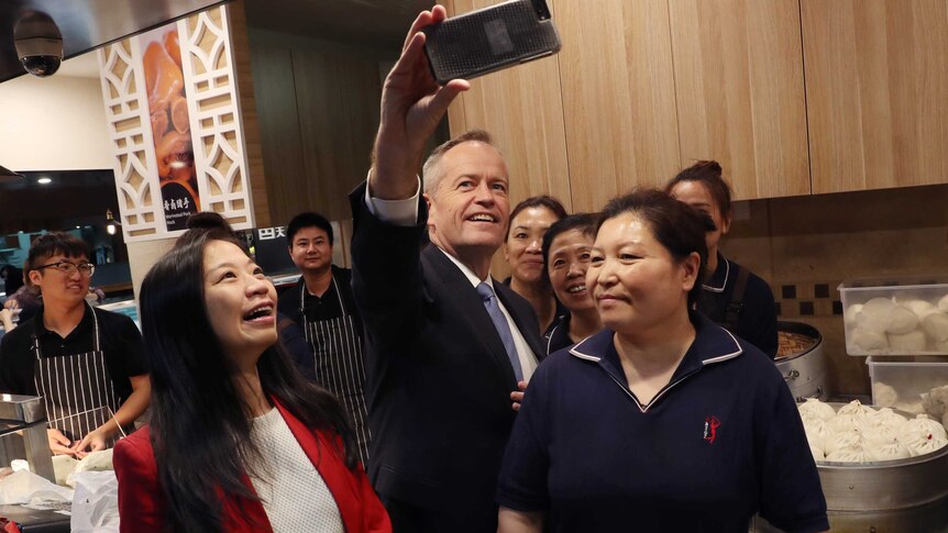 Opposition Leader Bill Shorten (centre) and Labor candidate for Chisholm Jennifer Yang (left) pose for a photograph.