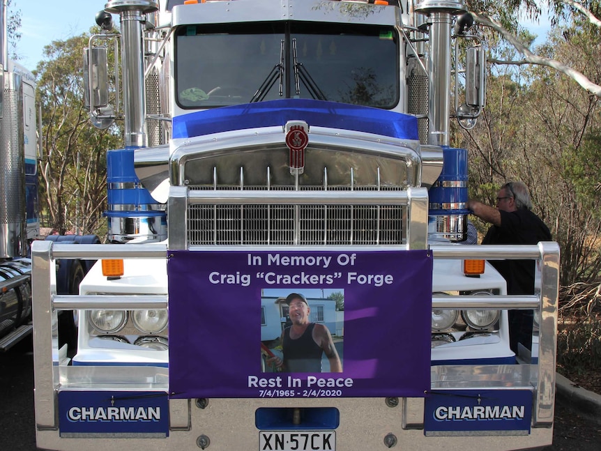 A truck with a purple banner celebrating Craig Forge's life.