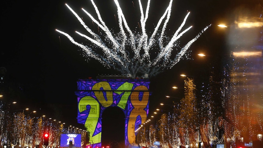 Paris' Arc de Triomphe has '2018' projected onto its arches as fireworks explode behind it.