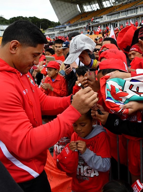 Tonga rugby league player Jason Taumalolo signs autographs for fans wearing the Tonga rugby team colours.