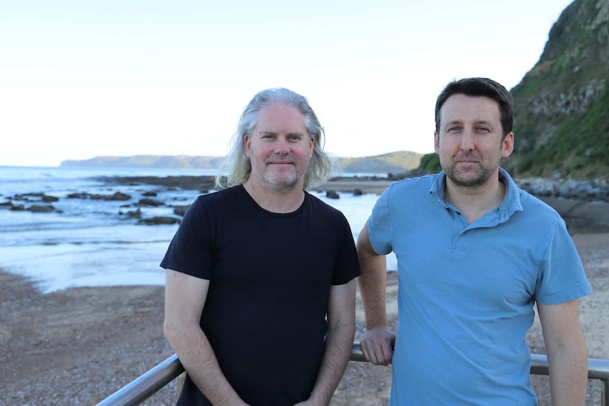 Twp men pose for photo at the beach.