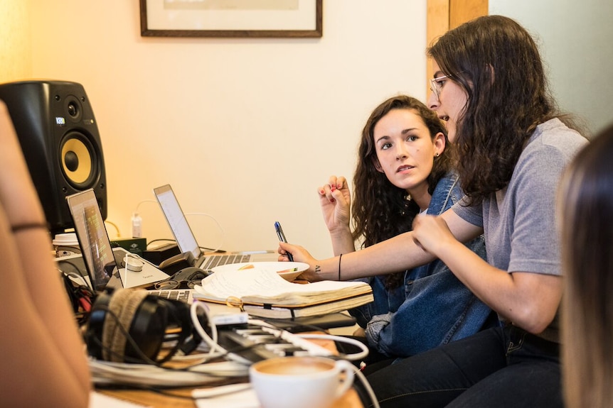 Sarah Aarons and Anna Robinson talk in front of a computer