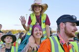 young girl and mum in high vis vests with young girl on shoulders.