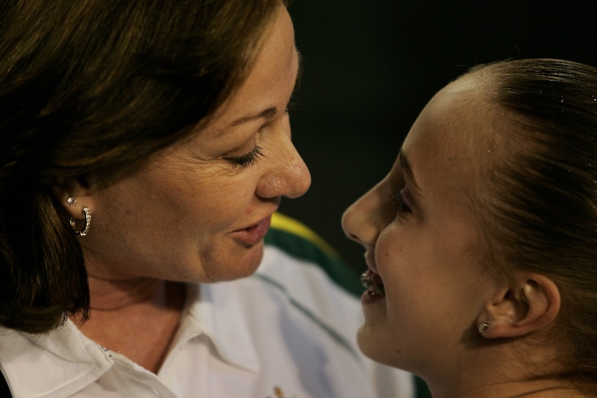 Gymnastics coach Peggy Liddick with her face close to that of gymnast Ash Brennan.