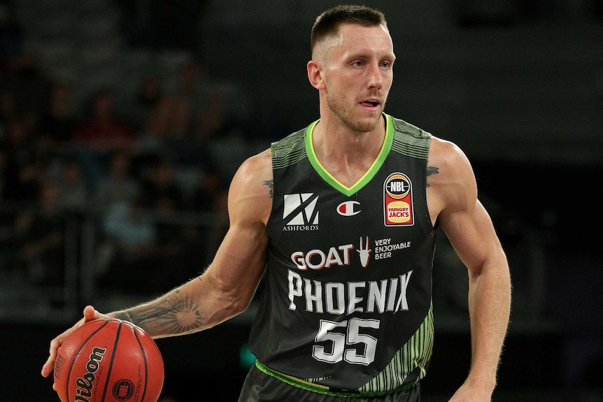 Mitch Creek dribbles the ball with his right hand while playing for the Phoenix in the NBL.