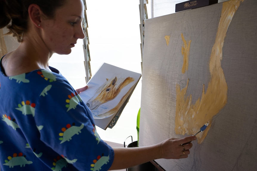 Woman painting canvas in a home studio