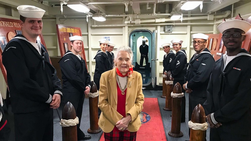 Elderly lady with US service people aboard a ship in Brisbane.
