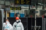 Forensic officers walk in front of the damaged Zaventem Airport terminal in Brussels.