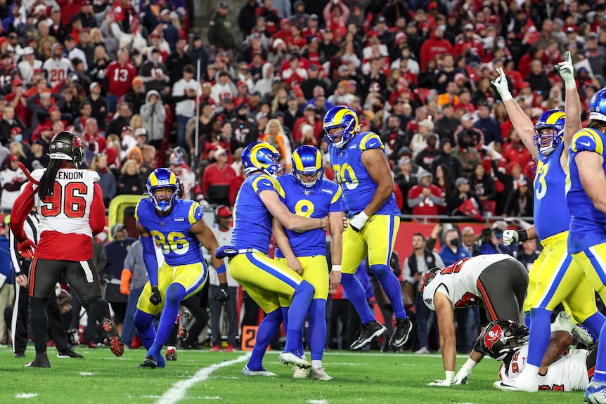 Rams players congregate to celebrate while Buccaneers players look sad