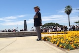 A former soldier wearing medals stands to attention at Kings Park War Memorial, Remembrance Day 2013.