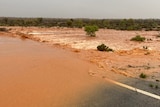 Brown water rushing over a road