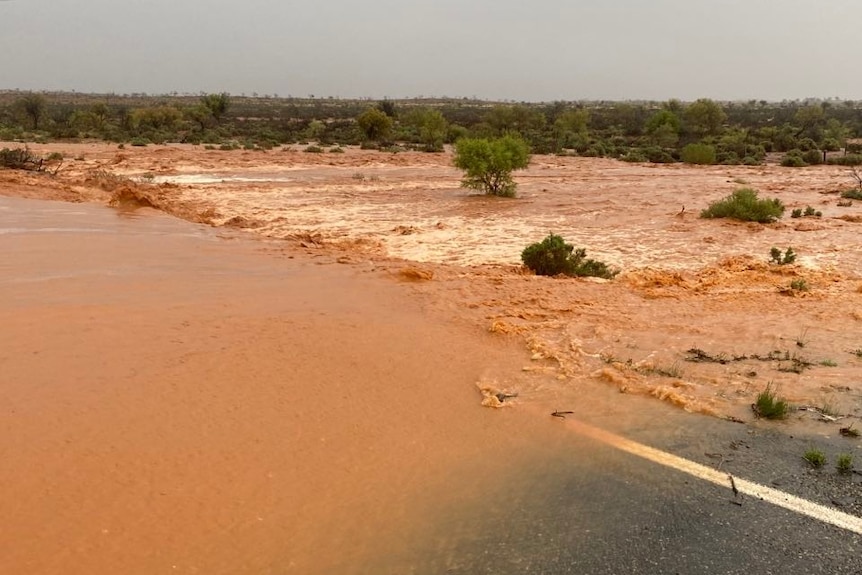 Brown water rushing over a road