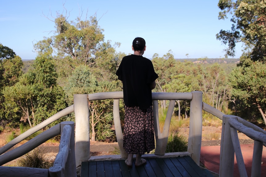 Myree looks out over bushland from her deck.