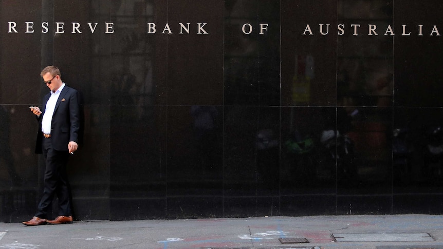 A man smokes next to the Reserve Bank of Australia headquarters.