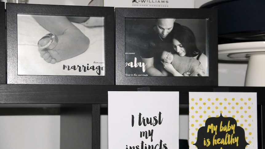 Family photos and positive affirmations on a wall in Natasha Quintanilla's home.