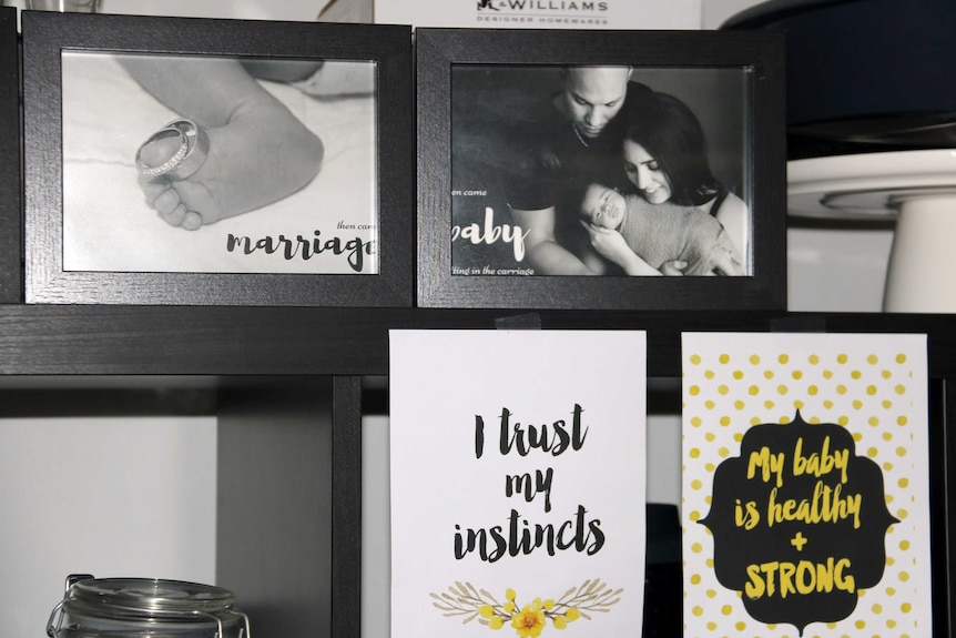 Family photos and positive affirmations on a wall in Natasha Quintanilla's home.