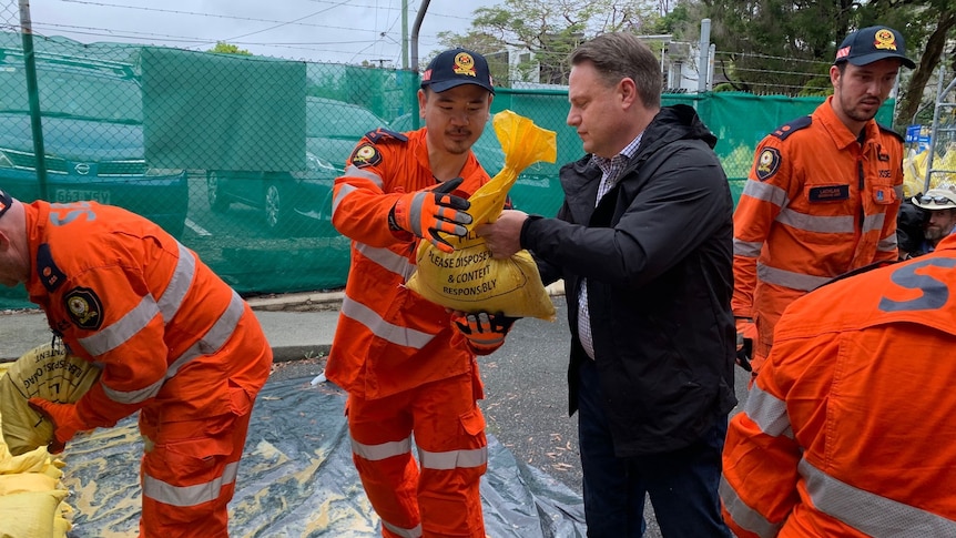 Brisbane Mayor Adrian Schrinner packing sandbags.