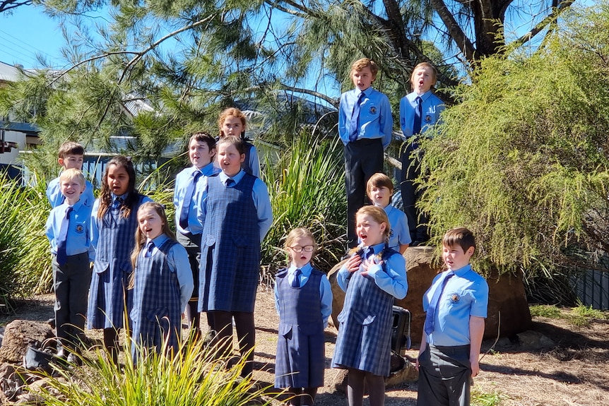A group of children in school uniform singing