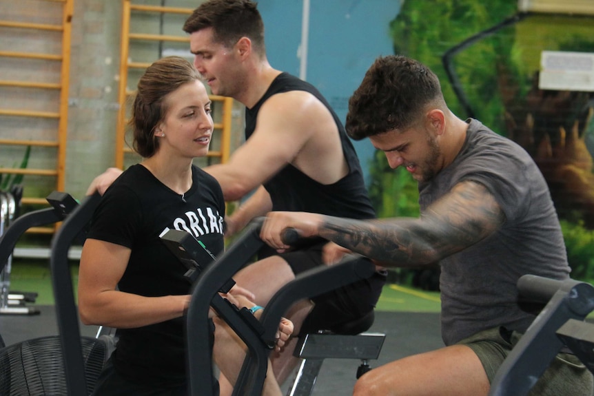 Darcia leonard coaches a male athlete through his set at the crossfit gym.