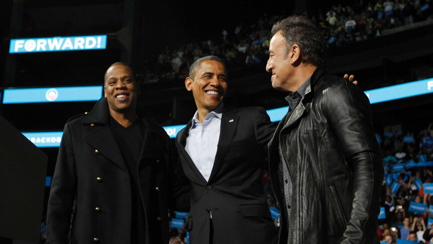 Barack Obama stands on stage with rapper Jay-Z and musician Bruce Springsteen at a campaign rally on the eve of elections.
