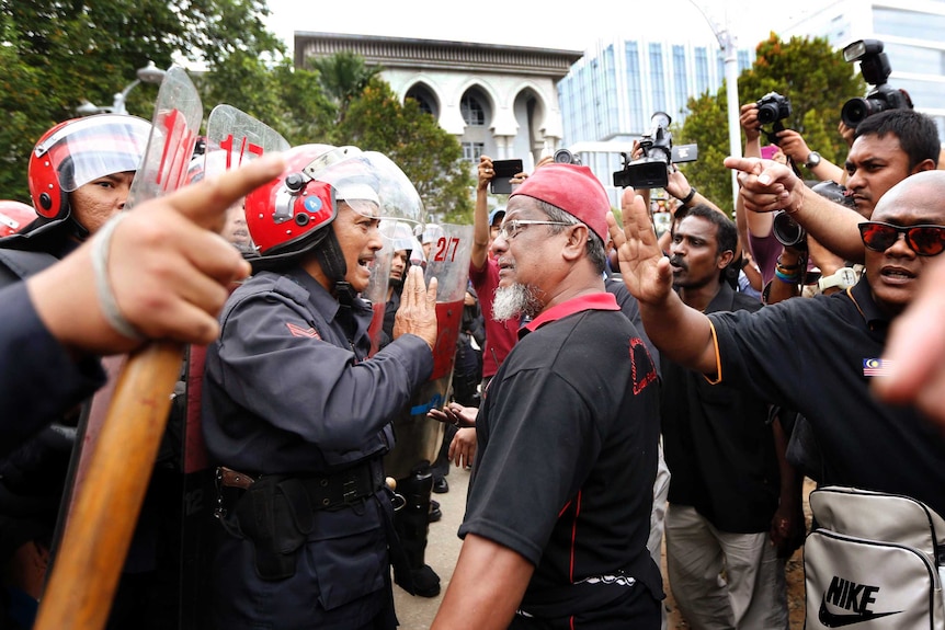 A supporter of Malaysian opposition leader Anwar Ibrahim clashes with a policeman