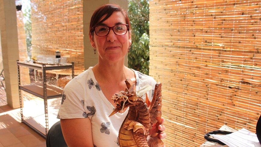 Lisa Menzel repairs a wooden dragon