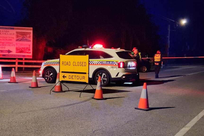 A police car parked near witches hats