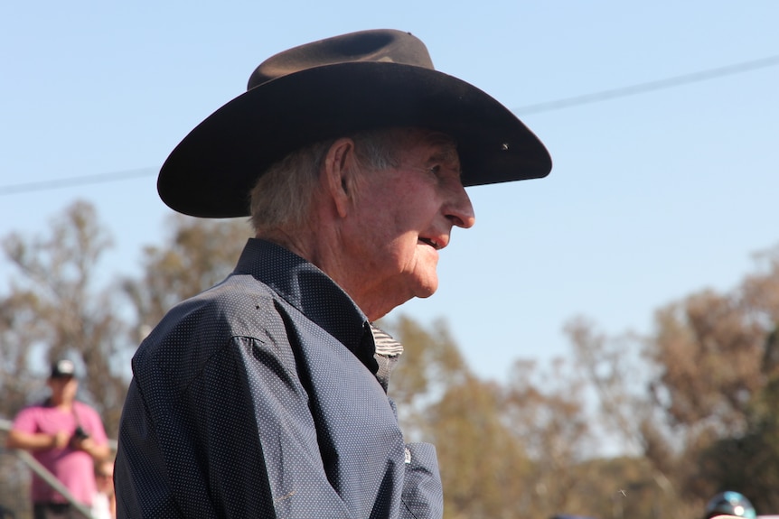 An elderly man in a dark cowboy hat, as seen in profile.