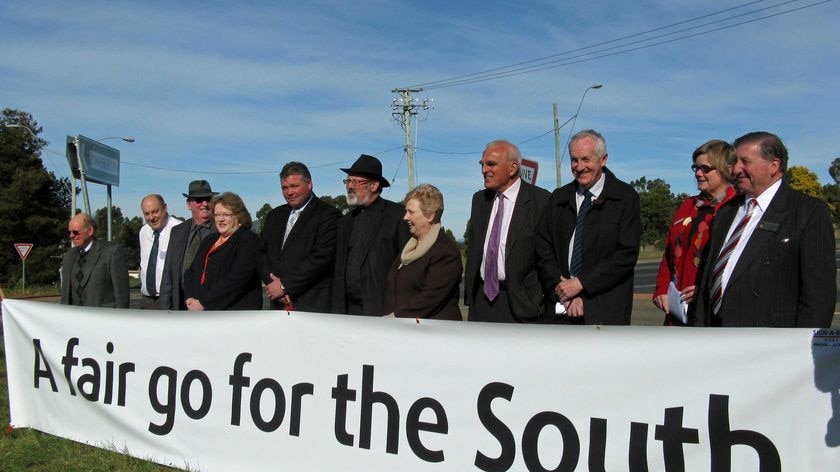 Southern Tasmanian Mayors with a banner calling for a better deal in federal road funding.