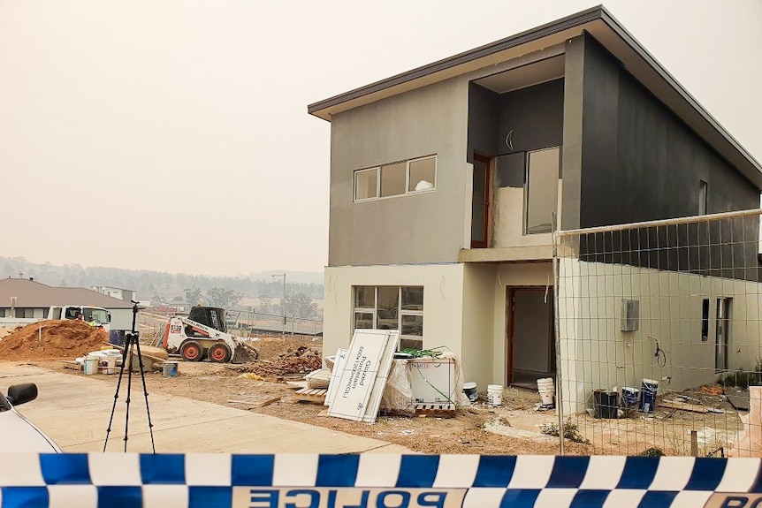 A building site with police tape in the foreground.