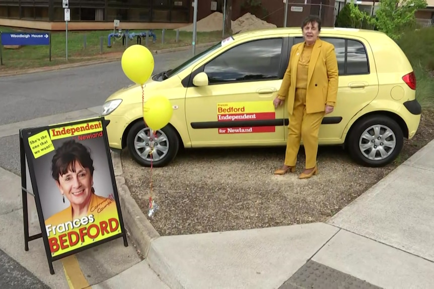 Independent MP Frances Bedford with her yellow car and a sign with her face on it