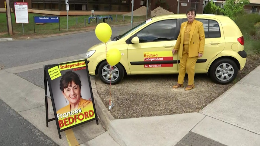 Independent MP Frances Bedford with her yellow car and a sign with her face on it