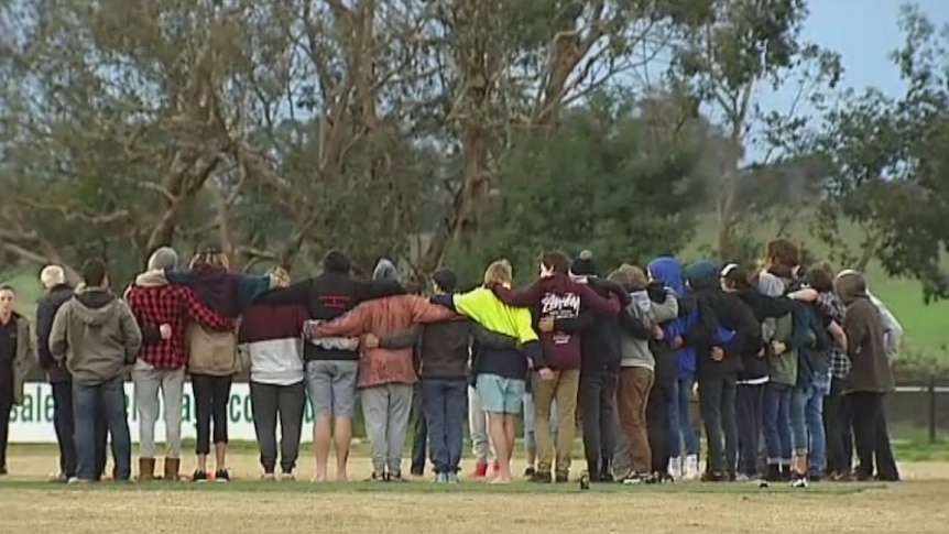 Members of the Yarra Glen football club grieve for mates